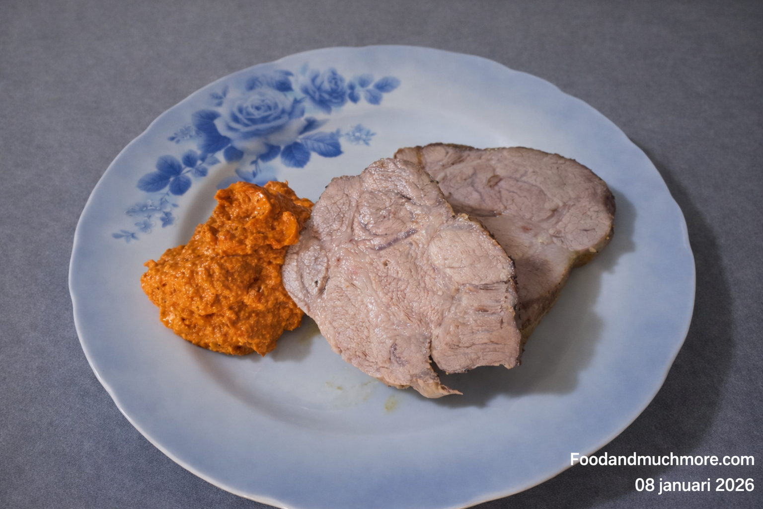 Grillad flÀskkarré serverad med romescosÄs pÄ rostad paprika och mandel