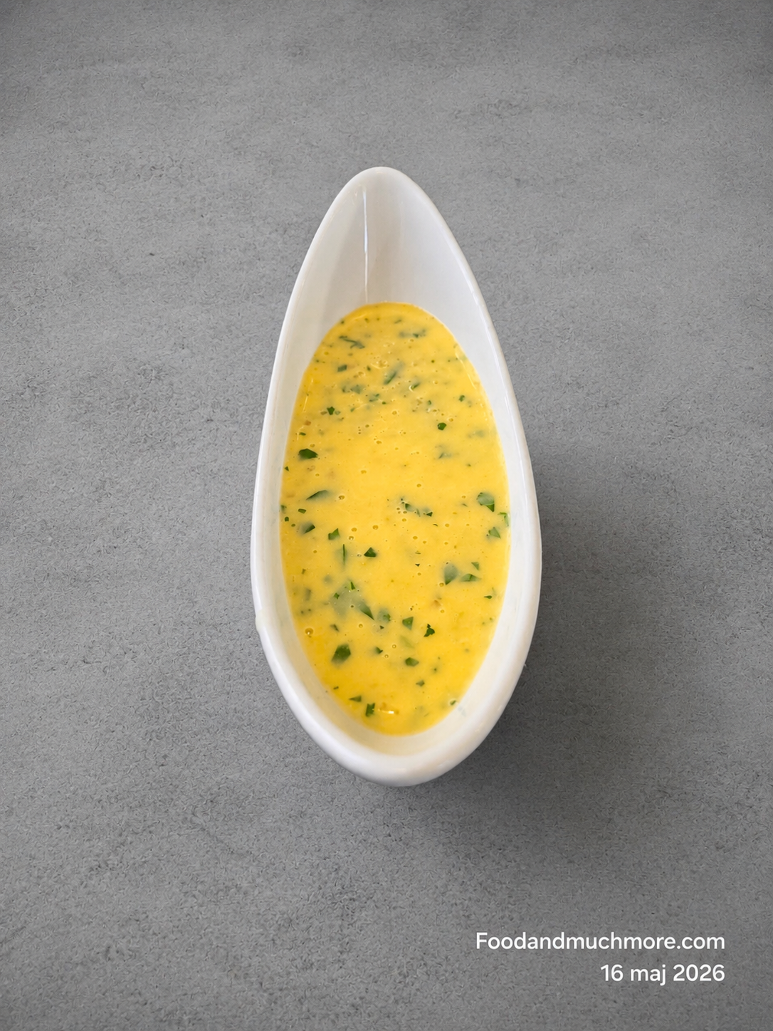 Krämig Beurre Blanc-sås i liten skål serverad till grillad fisk och citron.